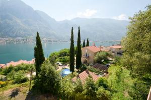 a house on a hill next to a body of water at Apartments Panorama in Kotor