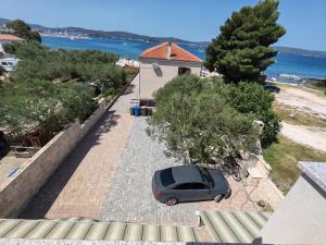 a car parked in a parking lot next to a house at Apartments Bosana XIV in Biograd na Moru