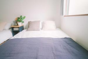 a bed with a blue blanket on top of it at リトリートコート薬院 in Fukuoka +74 photos