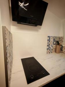 a flat screen tv hanging on a wall above a stove at Nice studio in Paris suburbs in Épinay-sur-Seine