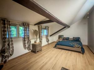 a bedroom with a blue bed and wooden floors at Independent studio in house - Paris suburbs in Épinay-sur-Seine