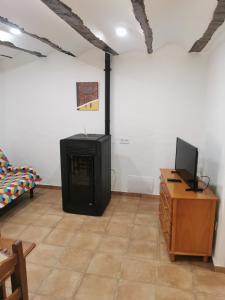 a living room with a television and a table at Casa Rural y Albergue Tormon in Tormón +47 photos