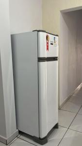ein weißer Kühlschrank, der in einem Raum neben einer Wand steht in der Unterkunft Lar Aconchego 2 in Palmas