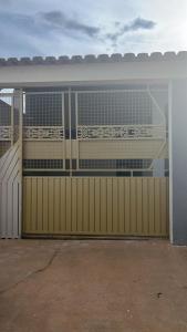 ein Gebäude mit einem hölzernen Garagentor mit einem Tor in der Unterkunft Lar Aconchego 2 in Palmas
