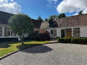a house with a tree and a gravel driveway at La Bergerie - Chambres d'hôtes entre terre et mer in Recques-sur-Course