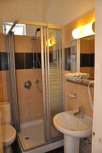 a bathroom with a shower and a sink and a toilet at Elena Hotel in Arkítsa