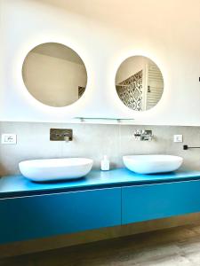 two sinks in a bathroom with two mirrors at Le Dimore di Giove in Bevagna