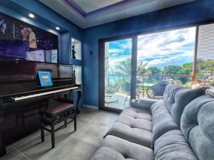 a living room with a couch and a piano at Amerigo Vespucci Mar e Ceu in Morro de São Paulo