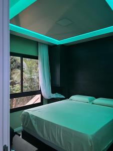 Schlafzimmer mit einem Bett mit blauem Licht in der Unterkunft Amerigo Vespucci Mar e Ceu in Morro de São Paulo