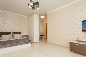 a bedroom with a bed and a flat screen tv at Apart-Kharkovskaya in Sumy