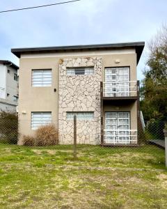 a large stone house with a balcony in a yard at Granville in Valeria del Mar