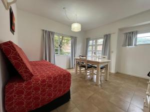 a living room with a red bed and a table at Granville in Valeria del Mar