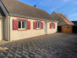 dom z czerwonymi okiennicami i podjazdem w obiekcie Maison familiale de plein pied - Parking gratuit w mieście Bavent