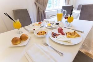 una mesa cubierta con platos de comida y bebida para el desayuno en Padam Boutique Hotel en Tirana