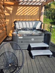 Una parrilla de barbacoa y una silla en una terraza. en Malczykówka-luksusowy dom & SPA, z widokiem na Tatry, en Bukowina Tatrzańska