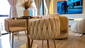 a dining room table with two chairs and a couch at Luxury, Comfort and Unforgettable View of Sandton in Johannesburg