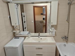 a white bathroom with a sink and a mirror at Tommy Apartman 2.0 in Hajdúszoboszló +70 photos