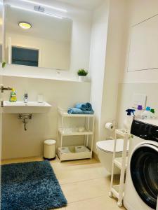 a bathroom with a sink and a washing machine at Stylish 19th-Floor Klingerka Apartment with Stunning Castle Views & Free Parking in Bratislava