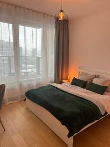 a bedroom with a large bed and a window at Stylish 19th-Floor Klingerka Apartment with Stunning Castle Views & Free Parking in Bratislava