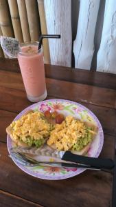 a plate of food on a table with a drink at Chalok Hostel in Koh Tao