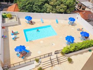 una vista aérea de una piscina con sombrillas azules en Flat Copacabana Mar Piscina e Sauna, en Río de Janeiro