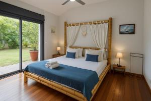 a bedroom with a large bed and a large window at Villa O'rizon Bleu - Piscine XXL et vue mer panoramique sur St Gilles les Bains in Saint-Gilles les Bains +28 photos