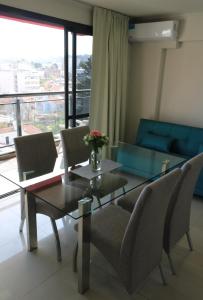 a dining room with a glass table and chairs at Departamento centro Carlos Paz con pileta in Villa Carlos Paz