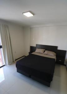 a bedroom with a black bed in a room at Departamento centro Carlos Paz con pileta in Villa Carlos Paz