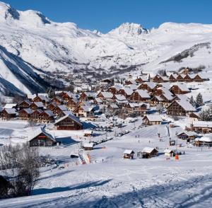 a village covered in snow with mountains in the background at Les sybelles in La Chal