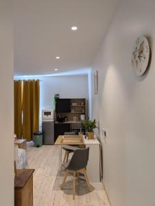 a living room with a table and a clock on a wall at Chez Steph in Le Puy en Velay