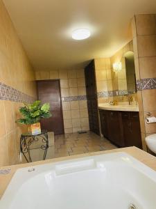 a bathroom with a tub and a toilet and a sink at Casa Santa Fe Colonia Santa Fe Tijuana BC in Rancho La Gloria