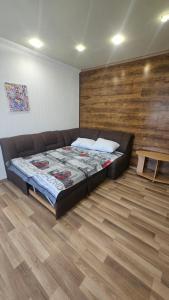 a bedroom with a bed and a wooden wall at Хостел Твій Дім в Пирятині in Pyryatyn