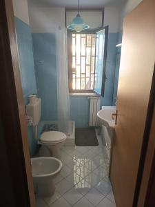 a bathroom with two toilets and a sink and a window at Come a Casa in Caserta +8 photos