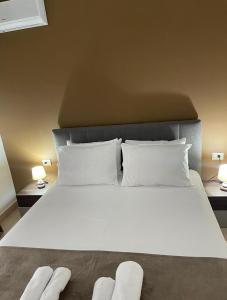 a large bed with white sheets and pillows at Noema Apartment 5 Maji - A Cosy Stay in Tirana in Tirana