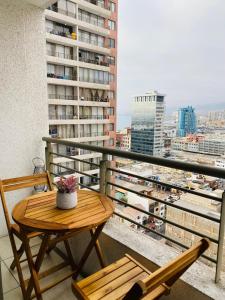 a table and chairs on a balcony with a view of a city at Fantástico Departamento Central-2Hab-2Baños in Antofagasta