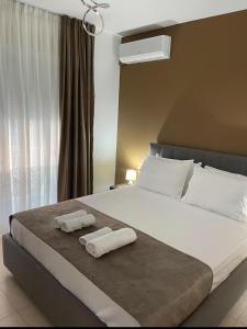 a bedroom with a large bed with two towels on it at Noema Apartment 5 Maji - A Cosy Stay in Tirana in Tirana