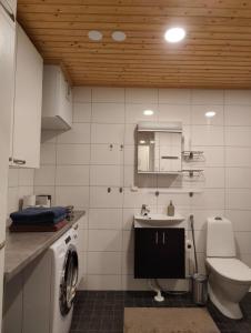 a bathroom with a washing machine and a sink at Cozy two-room apartment with sauna in Sodankylä