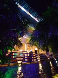 a building with a fence and a pool at night at The Hoxton Bay in Weligama