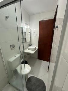 ein Badezimmer mit Toilette und Glasdusche in der Unterkunft Paraíso de Toque Toque Grande in São Sebastião