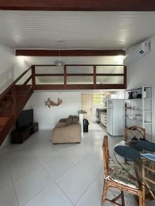ein Wohnzimmer mit einem Hochbett und einer Küche in der Unterkunft Paraíso de Toque Toque Grande in São Sebastião