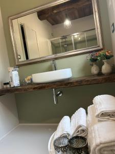 Un baño con lavabo, espejo y toallas. en Casale21, en Castiglion Fiorentino 41 fotos más