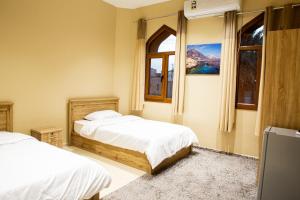 ein Schlafzimmer mit zwei Betten und einem Fenster in der Unterkunft The Garden Inn نزل الحدیقة in Nizwa + 30 Fotos