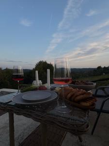 a table with two glasses of wine and a plate of food at Tea House Ponoarele in Ponoarele