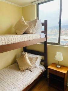 two bunk beds in a room with a window at Fantástico Departamento Central-2Hab-2Baños in Antofagasta