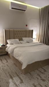 ein Schlafzimmer mit einem großen Bett mit weißer Bettwäsche in der Unterkunft شقة الراحة in Tabuk