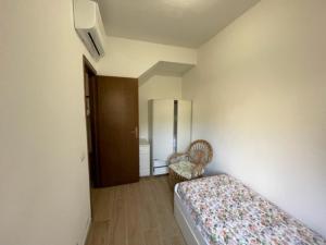 a bedroom with a bed and a chair in it at Villetta con giardino di fronte al mare in Principina a Mare
