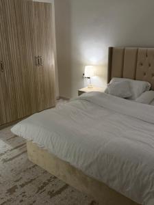 ein Schlafzimmer mit einem großen weißen Bett und einer Lampe in der Unterkunft شقة الراحة in Tabuk + 16 Fotos