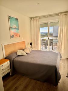 a bedroom with a bed with a view of the ocean at Apartamento nuevo en la playa- MET- Oliva Nova Golf in Oliva
