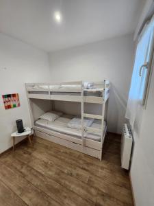 a white bunk bed in a room with a wooden floor at Gîte Le rossignol des murailles in Le Bosc +46 photos