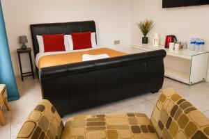 a bedroom with a bed with a black leather headboard at Countryside Retreat in Codicote +9 photos